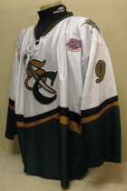 Adam Krug # 9 2003-04 White. 25th USHL Aniversary Season. Worn during the 03-04 season by Adam Krug. This season marked the 25th Anniversary of the USHL. Each team sported the special anniversary patch on home and away jerseys that season. Has alternate shoulder patches and USHL crest on front. This was the last season of the SC logo. Manufactured by OT Sports and is a size 56.