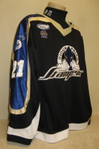 Anthony Canzoneri Sioux Falls Stamepde 2002-03 #21 Worn during the 2002-03 USHL season. Shows great wear. Made by Gemini and is a size 54. NOB, shoulder patches, USHL & Gemini Crest on front. This style of jersey was worn for the first four seasons. 1999-2000 was Sioux Falls' first season in the league.