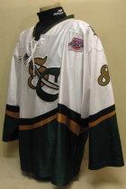  Lious Liotti 2003-04 # 8 White. 25th USHL Aniversary Season Worn during the 03-04 season by Lious Liotti. This season marked the 25th Anniversary of the USHL. Each team sported the special anniversary patch on home and away jerseys that season. Has alternate shoulder patches and USHL crest on front. This was the last season of the SC logo. Manufactured by OT Sports and is a size 56.