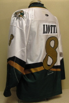  Lious Liotti 2003-04 # 8 White. 25th USHL Aniversary Season Worn during the 03-04 season by Lious Liotti. This season marked the 25th Anniversary of the USHL. Each team sported the special anniversary patch on home and away jerseys that season. Has alternate shoulder patches and USHL crest on front. This was the last season of the SC logo. Manufactured by OT Sports and is a size 56.