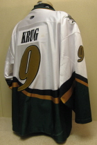 Adam Krug # 9 2003-04 White. 25th USHL Aniversary Season. Worn during the 03-04 season by Adam Krug. This season marked the 25th Anniversary of the USHL. Each team sported the special anniversary patch on home and away jerseys that season. Has alternate shoulder patches and USHL crest on front. This was the last season of the SC logo. Manufactured by OT Sports and is a size 56.