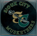 This Souvenir puck was only available only at the team store. Issued during the 2000-01 season, it features the new Musketeer logo introduced during the 2000 season. This style was never used during USHL Musketeer games.